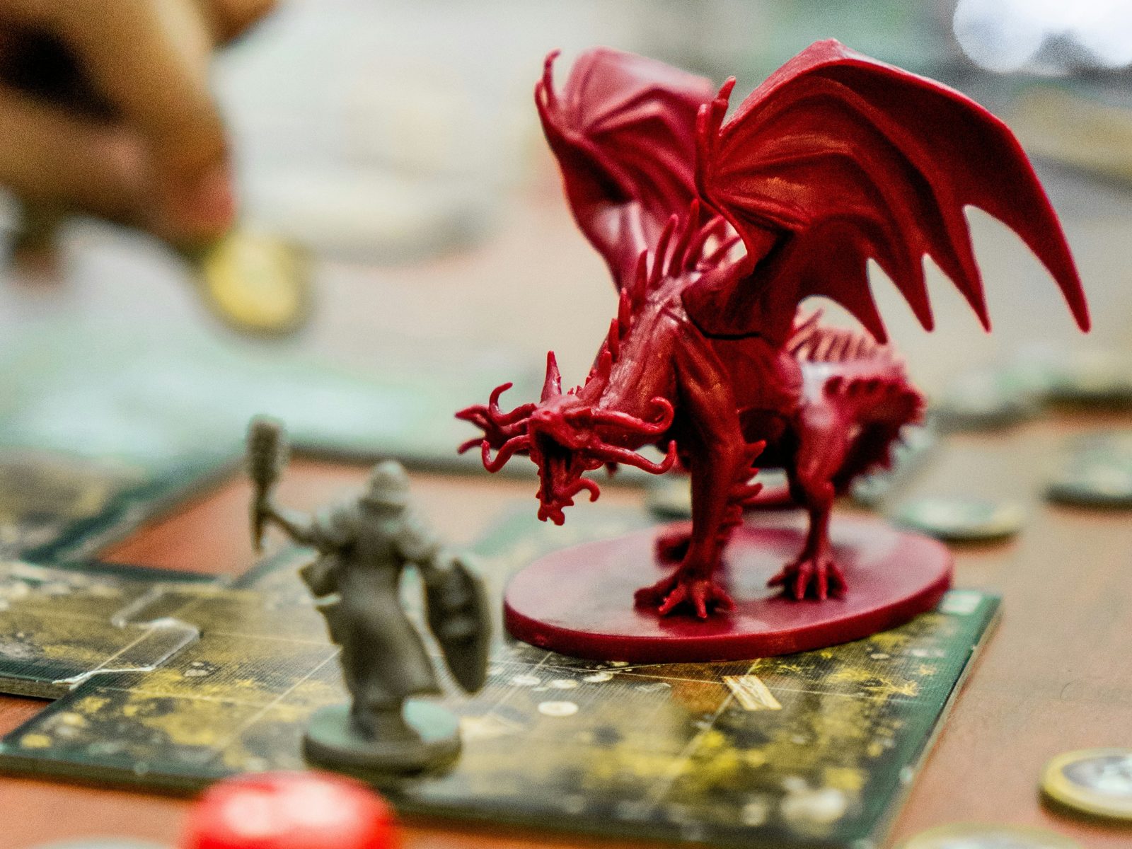 Painted fantasy miniatures, including a red dragon, on a tabletop game board